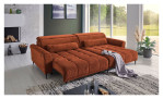 Komfort-Wohnlandschaft Lilly in einem orangefarbenen Cordstoff mit zwei Zierkissen. Auf einem dekorierten Hintergrund.