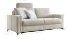 Komfort-Schlafsofa „Pickering“ von Hukla in Hellbeige mit 2 grauen Kissen, breiten Armlehnen, Kopfstütze und Metallgestell.