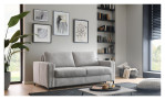 Modernes Wohnzimmer mit einem Hukla Basis-Schlafsofa „Pickering“, Wandbildern, Bücherregalen, einer Pflanze und einem Couchtisch auf einem dunklen Teppich.