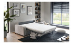 Modernes Wohnzimmer mit dem Schlafsofa „Pickering“ von Hukla Basis, einem schwarzen Teppich, Wanddekoration und einem Fenster mit Jalousien.