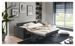 Ein graues Hukla Basis-Schlafsofa „Pickering“ mit Kaltschaummatratze steht in einem modernen Raum mit Kunstwerken und großen Fenstern.