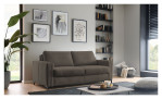 Ein modernes Wohnzimmer ist mit einem dunklen „Basis“-Schlafsofa „Pickering“ von Hukla, Wandbildern, Bücherregalen, einer Pflanze und einem Couchtisch ausgestattet.