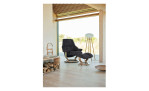Relaxsessel mit Hocker Stressless Reno (M) Classic, in der Farbausführung Black, in einem Raum stehend