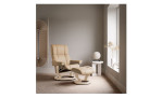 Relaxsessel mit Hocker Stressless Mayfair, in der Farbausführung Sand, in einem Raum stehend