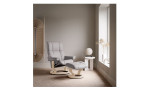 Relaxsessel mit Hocker Stressless Mayfair, in der Farbausführung Light Grey, in einem Raum stehend