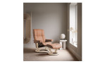 Relaxsessel mit Hocker Stressless Mayfair, in der Farbausführung Orange, in einem Raum stehend