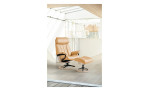 Relaxsessel mit Hocker Stressless Paul (m) Signature, in der Farbausführung Honey, in einem Raum stehend