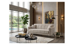 Modernes Wohnzimmer mit einem 3-Sitzer-Sofa „Lexi“, 2 Kissen, Bonellfederkernpolsterung, abstrakter Kunst, Pflanzen und großen Fenstern.