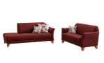Auf weißem Hintergrund sind zwei rote MONDO Quadra-Sofas von Mondo mit Kissen mit Blumenmuster und Holzbeinen zu sehen.