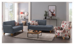 Modernes Wohnzimmer mit der Mondo Komfort-Sitzgruppe MONDO Quadra, einem Sessel mit Blumenmuster, einem Couchtisch, einem Teppich und Wandbildern.