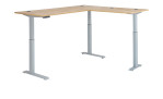 Elektro-Winkelschreibtisch mit holzfarbener Tischplatte und silbernem Gestell hoch eingestellt.