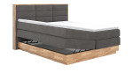 Boxspringbett MONDO NATUR Incana in einem Stoffbezug in Dark Grey und einem Sichtholzrahmen in Eiche. mit geöffneten Bettkasten