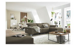 Komfort - Ecksofa Musterring MR 370, in der Farbausführung sand mit einem Hocker, in einem Raum stehend