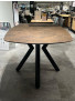 Der Bartisch „Masura“ ist ein brauner, quadratischer Esstisch mit ovalen Kanten und Metall-Schwarz-Beinen, der im Ausstellungsraum zu sehen ist.