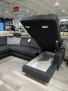 Ecksofa Planoform Nizza als Modulsofa mit offenem Stauraum, ausgestellt in einem Showroom mit Holzboden.