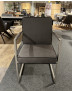 Stuhl „Mondo Natur Carpa“ aus Mikrofaser in der Farbe Onyx mit Armlehnen aus Edelstahl-Rundrohr, ausgestellt im Showroom.