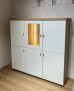 Hochschrank „Vito Idamo“ in Tonweiß mit Platte aus Alteiche, 4 Massivholztüren und einer LED-beleuchteten Glasvitrine.