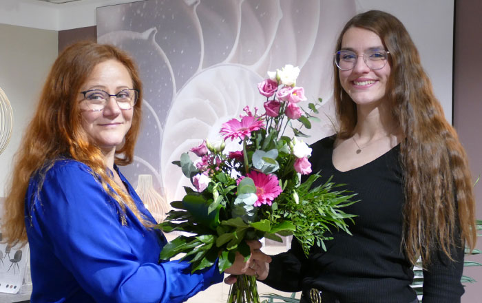 Amara Heisecke bekommt Blumenstrauß für abgeschlossene Ausbildung