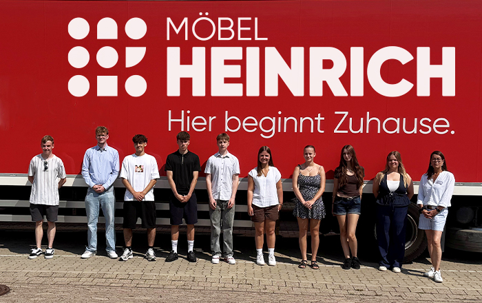 Möbel Heinrich Azubis stehen vor einem Möbel Heinrich Lkw