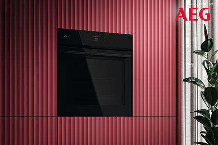 Schwarzer Einbau-Backofen von AEG in einer roten geriffelten Küchenfront eingebaut.