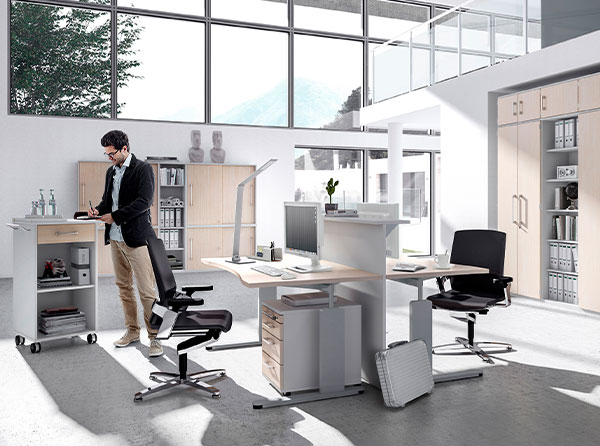 Büroraum mit Regalen, Schreibtischen und Rollcontainern in Grau mit Holzfronten