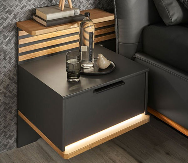 Schwarzer Nachttisch mit Büchern und Wasserglas auf der Abstellfläche