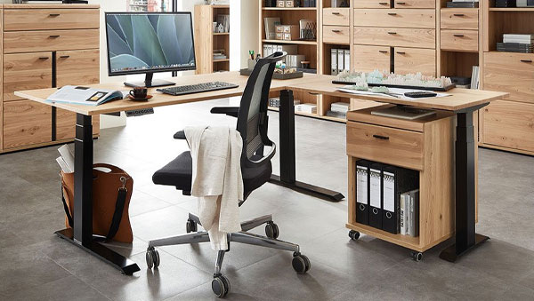 Eckschreibtisch aus hellem Holz und schwarzem Metallgestell, ergonomischer Bürostuhl mit Netzrücken und Rollcontainer mit Ordnern