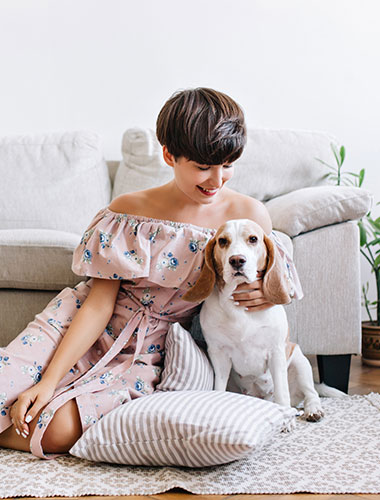 Frau und Hund sitzen vor einem Sofa