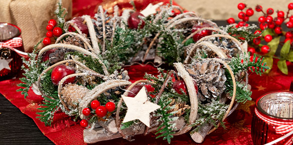 Kranz mit Tannenzapfen, roten Äpfeln, weißen Sternen und weiteren Absetzungen