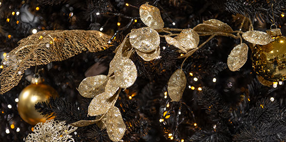 Goldfarbene Girlande am Weihnachtsbaum mit goldenen Deko-Blatt und goldenen Christbaumkugeln