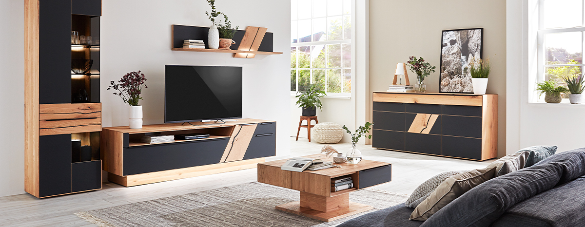 Modernes Wohnzimmer mit Möbelserie aus Holz und Anthrazit-Elementen, bestehend aus Wohnwand mit Vitrine und Wandregal, Sideboard und Couchtisch