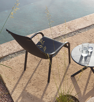 Gartensessel Net Lounge in Anthrazit neben kleinem Tisch mit Wassergläsern am Ufer