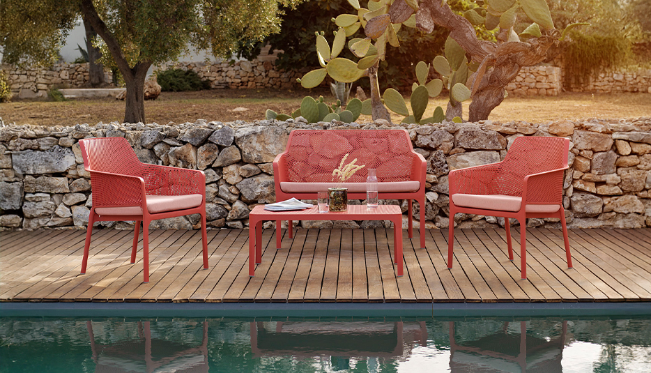 Gartenmöbelgruppe Net in Corallo mit zwei Stühlen, Gartenbank und Net Table 100 auf Terrasse