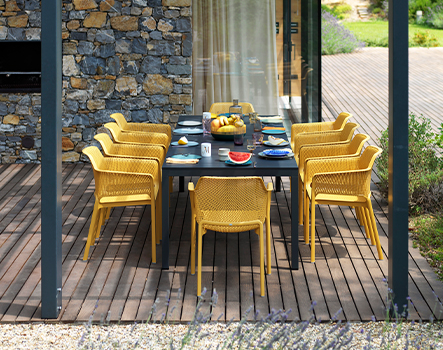 Gartentisch Rio 210 in Anthrazit mit Net Gartenstühlen in Senape auf Holzterrasse unter Pergola