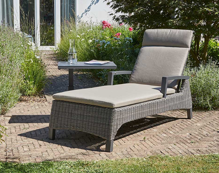 Gartenliege Corido mit grauem Polster und Armlehnen im Garten