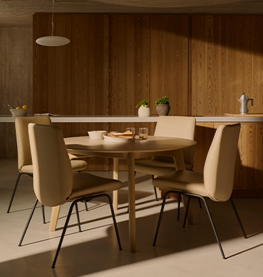 Runder Holztisch mit vier mit Stressless Laurel Esszimmerstühlen.