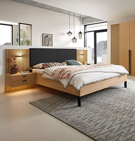 Bettanlage mit Holzpanellen und anthraziten Kopfteil